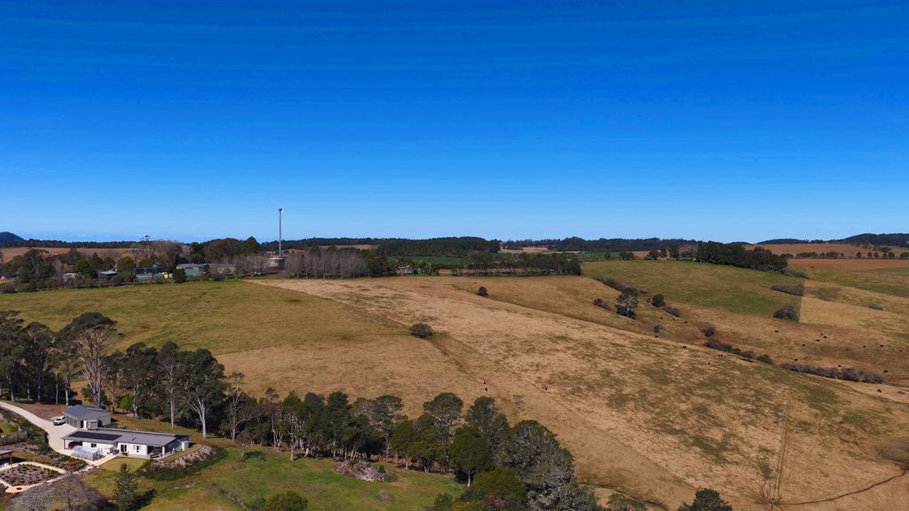 Australian farmland and an isolated homestead seen from the air in early light