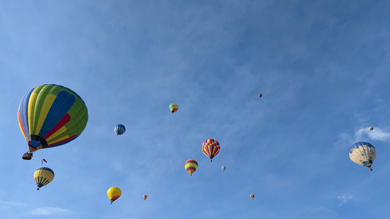 Hot air balloons inflating and rising over the festival field at the International de montgolfieres de Saint-Jean-sur-Richelieu, Quebec