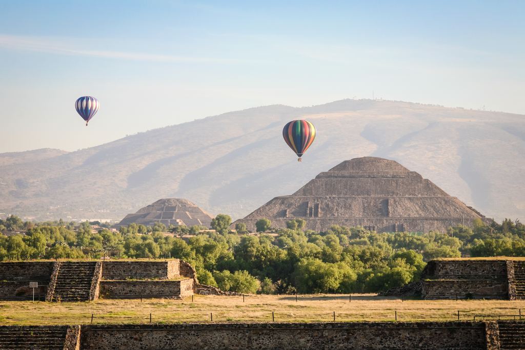 Several hot air balloons in flight above the pyramids of Teotihuacan, Mexico, early in the morning