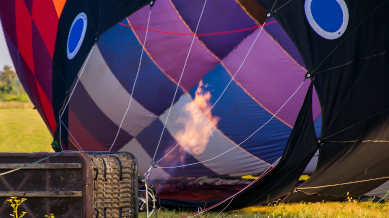 Crew hold the mouth of the envelope open while the burner fills it with hot air.