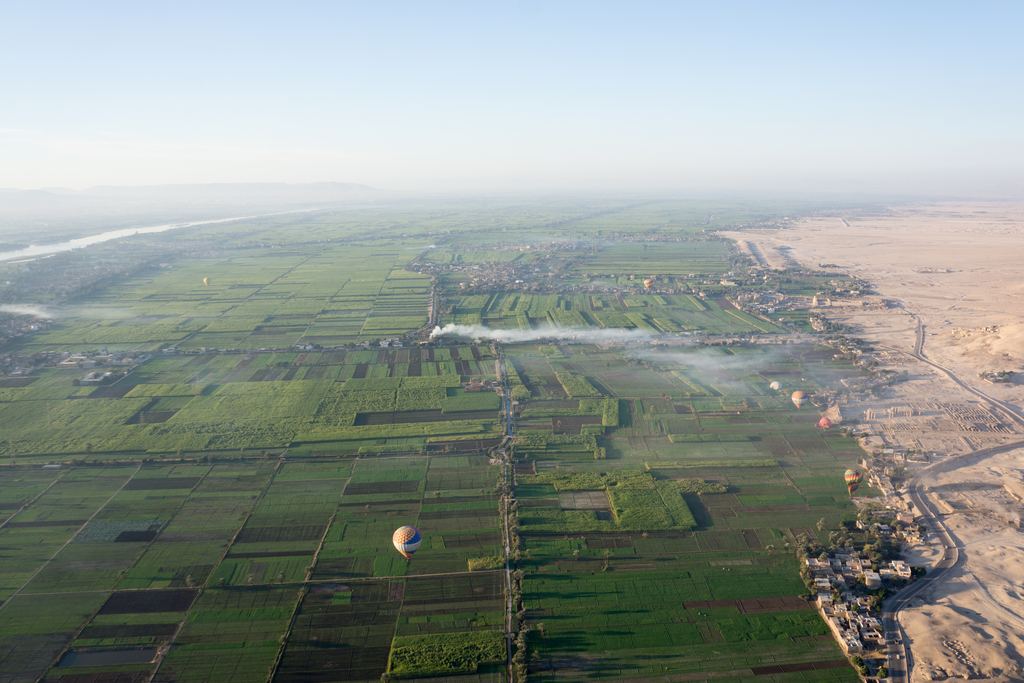 The crop limit in the Nile valley near Luxor, Egypt: irrigated green fields ending in a sharp line against bare desert