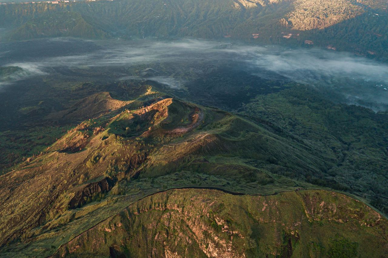 Forested hills with morning fog lying in the valleys, seen from the air at first light