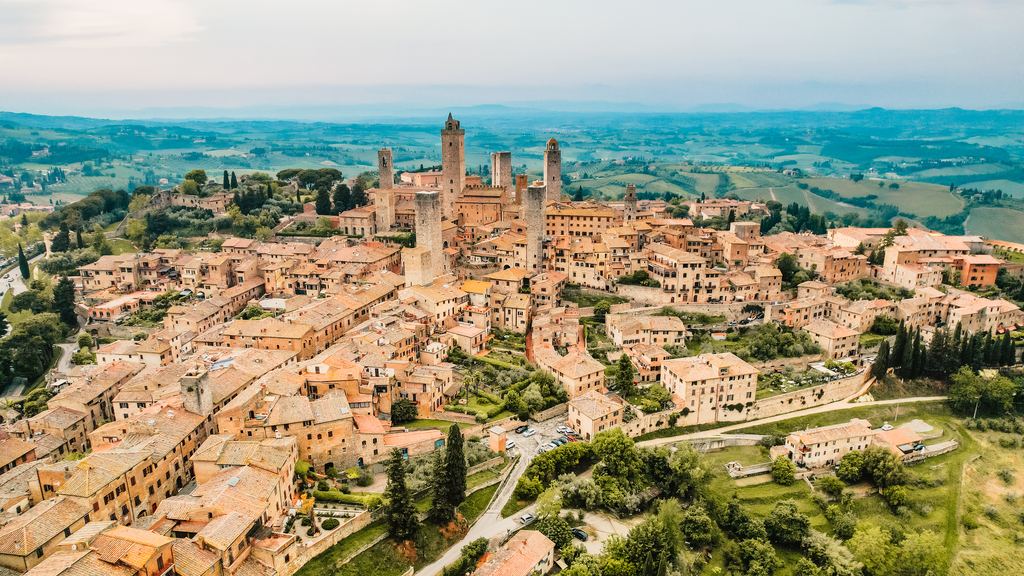The medieval towers of San Gimignano above the hill town, seen from the air in the province of Siena